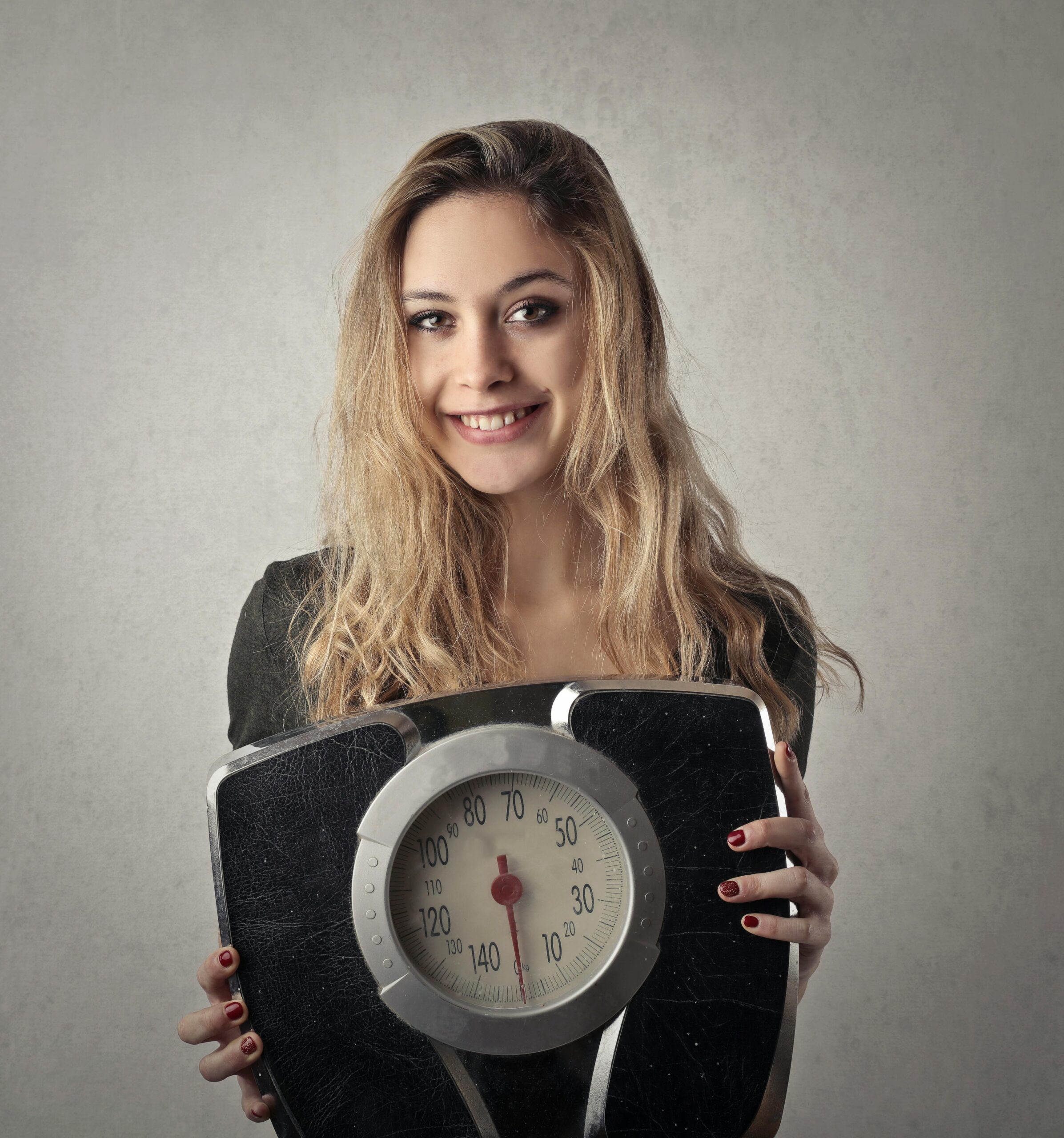 Woman in black shirt holding black and silver weight scale