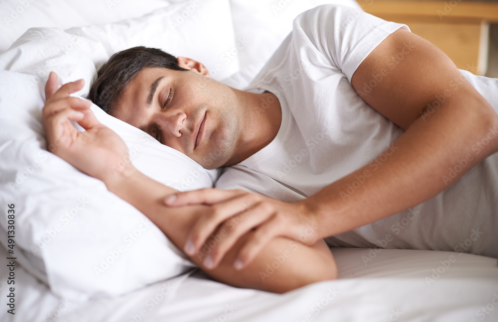 Is there anything better than a lie in. Shot of a young man sleeping in bed.